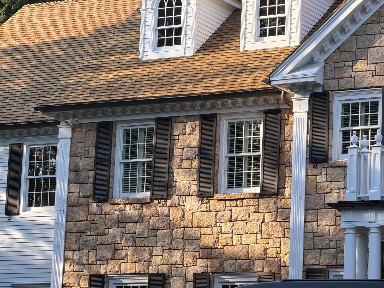Cedar shake roofline detail with dentil molding and copper downspout